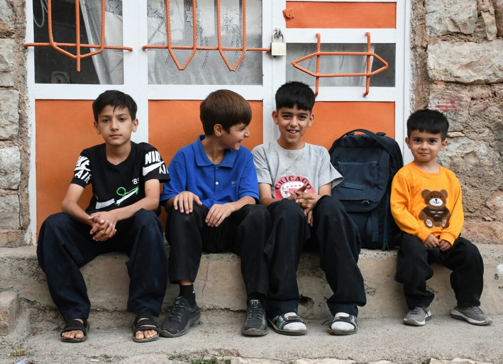 Four young boys sitting together as friends.